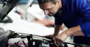 mechanic-working-under-hood-of-car_573x300