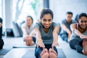a woman touching her toes in yoga class